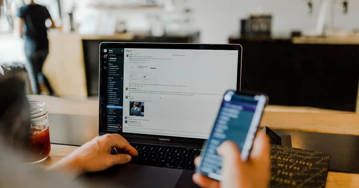 A customer checking a billing message on their phone at a laptop