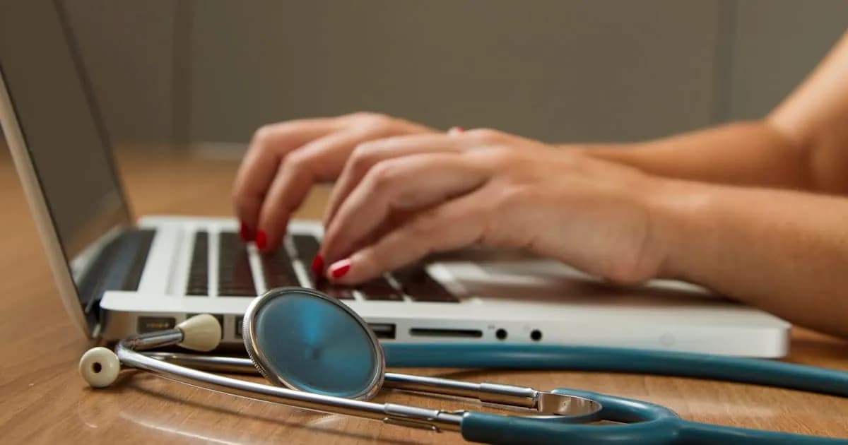 A clinic laptop with a stethoscope resting beside it